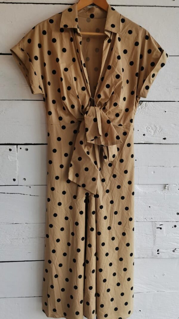 Vestido beige con dots negros. Tipo camisero, largo. Con moño en cintura, al frente.