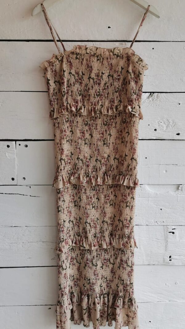 Vestido body conscious beige con estampado mini de flores rosas. Tirantes, resorte y olán en todo el vestido.