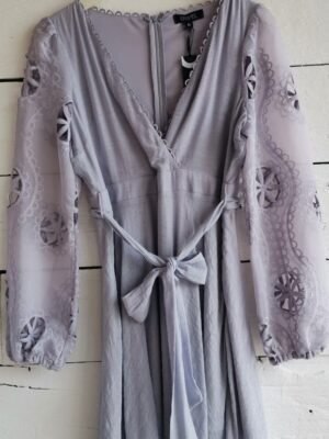 Vestido lila cruzado con mangas farol bordadas y texturizadas.