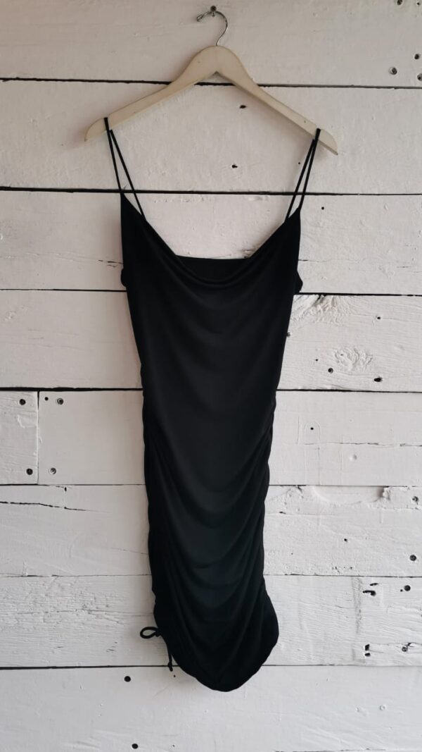 Vestido negro con tirantes y jareta en un costado.