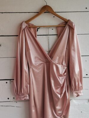Vestido palo de rosa satinado con manga larga farol. Escote profundo y falda envolvente.